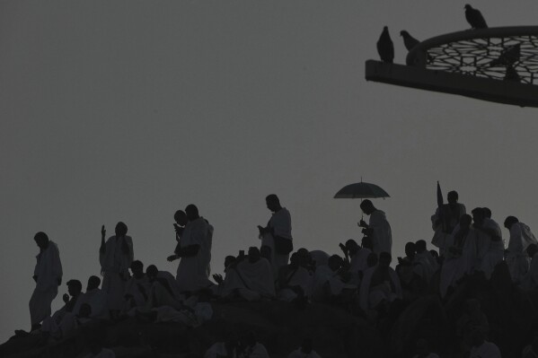Muslim pilgrims gather a top of the rocky hill known as the Mountain of Mercy, on the Plain of Arafat, during the annual Hajj pilgrimage near the holy city of Mecca, Saudi Arabia, Thursday, June 5, 2025. (AP Photo/Amr Nabil)