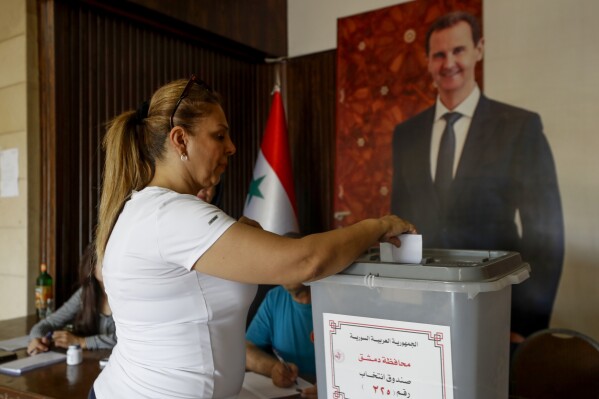 A Syrian woman casts her vote at a polling station during the Syrian parliamentary election in Damascus, Syria, Monday, July 15, 2024. Syrians were voting for members of a new parliament in an election Monday that was expected to hold few surprises but could pave the way for a constitutional amendment to extend the term of President Bashar Assad. (AP Photo/Omar Sanadiki)