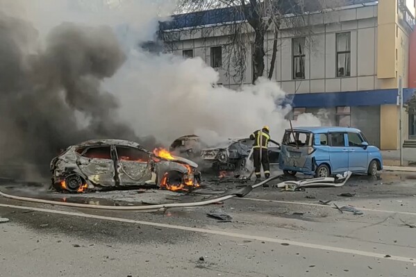 FILE - In this photo taken from video released by Russia Emergency Situations Ministry telegram channel on Saturday, Dec. 30, 2023, firefighters extinguish burning cars after shelling in Belgorod, Russia. Russian air defenses downed dozens of Ukrainian drones aimed at occupied Crimea and southern Russia, officials said Friday Jan. 5, 2024. (Russia Emergency Situations Ministry telegram channel via AP, File)