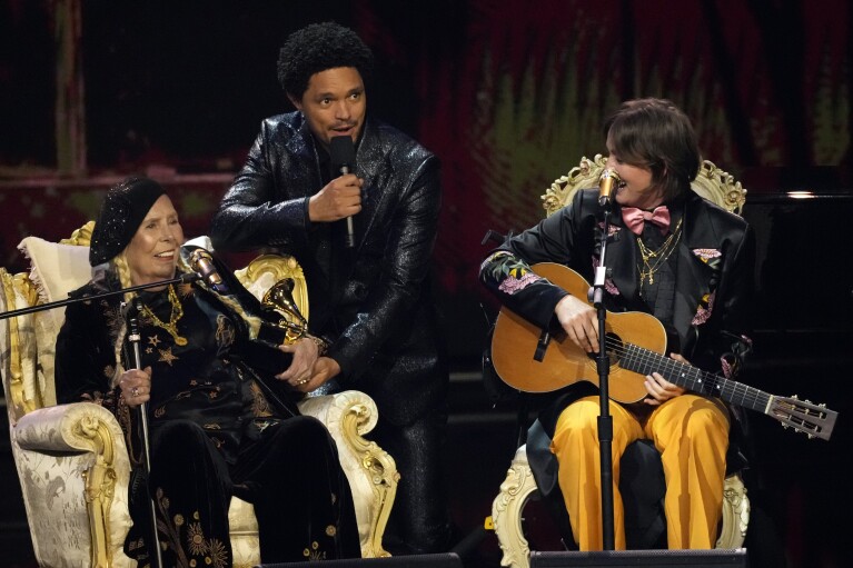 Joni Mitchell, from left, host Trevor Noah, and Brandi Carlile appear during the 66th annual Grammy Awards on Sunday, Feb. 4, 2024, in Los Angeles. (AP Photo/Chris Pizzello)