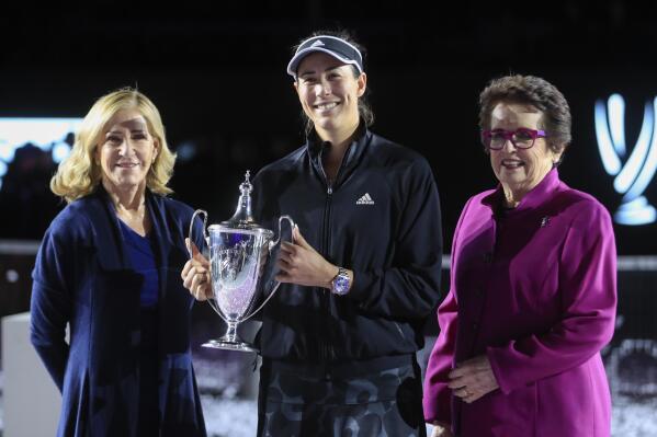Garbiñe Muguruza, of Spain, center, holds the trophy accompanied by former tennis players Billie Jean King, right, and Chris Evert after defeating Anett Kontaveit, of Estonia, at the final match of the WTA Finals tennis tournament in Guadalajara, Mexico, Wednesday, Nov. 17, 2021. (AP Photo/Refugio Ruiz)