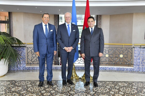 In this image released by Morocco's Foreign Ministry, Morocco Foreign Minister Nasser Bourita, right, and Morocco's Permanent Representative to the United Nations Omar Hilale, left, welcome UN Secretary General's Personal Envoy for Western Sahara, Staffan de Mistura, as he visits the region, in Rabat, Morocco, Friday, Sept. 8, 2023. (AP Photo via Morocco Foreign Ministry)