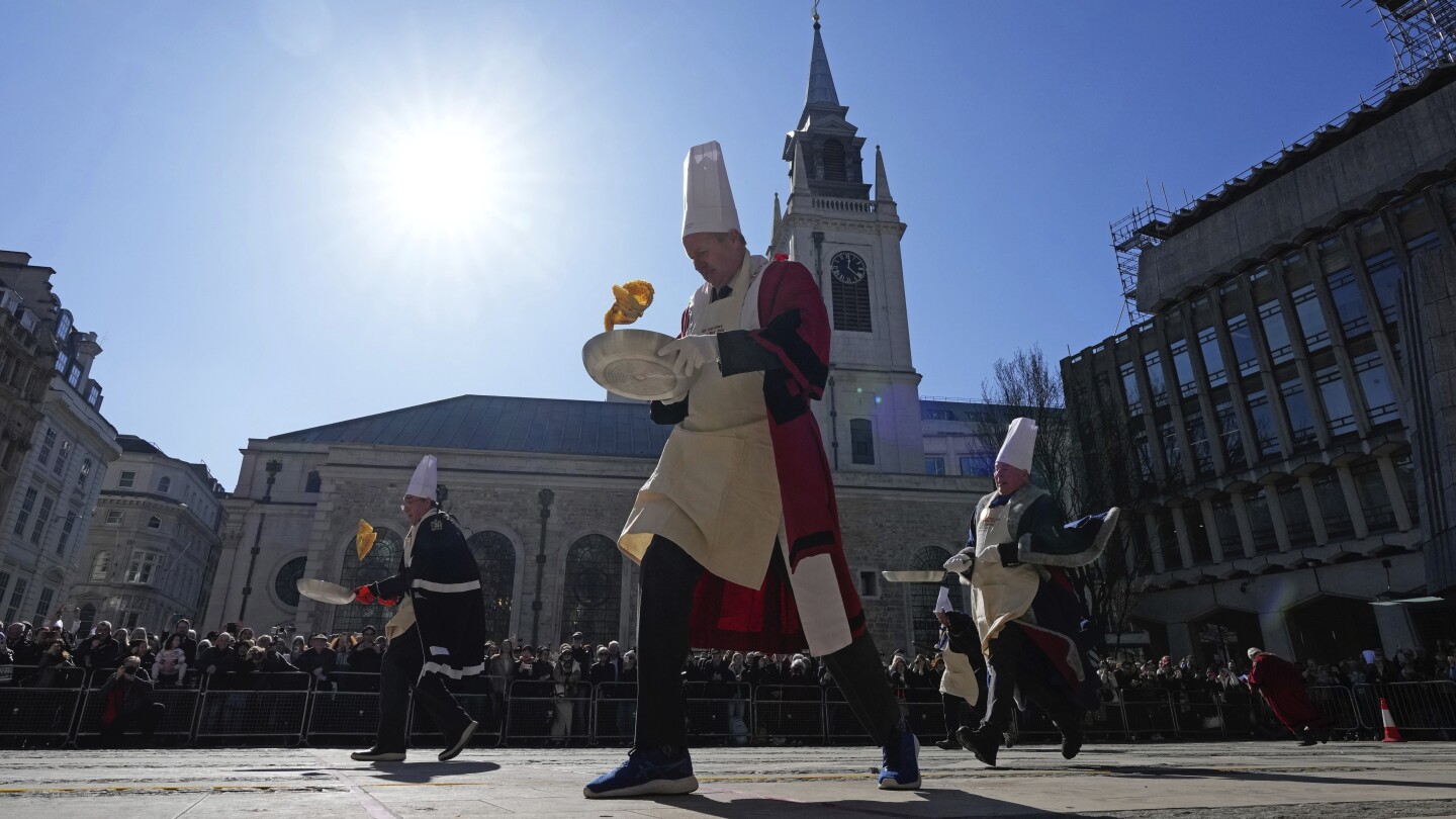 Hundreds cheer as runners with fry pans race to mark Pancake Day