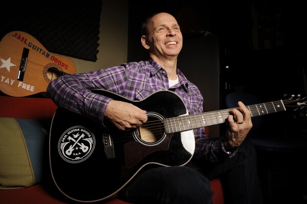 FILE - Guitarist Wayne Kramer, founder of the band the MC5, plays one of the instruments that will be provided to jail inmates as part of the Jail Guitar Doors USA initiative, Monday, Jan. 16, 2012, at Kramer's recording studio in Los Angeles. Kramer, died Feb. 2, 2024, at age 75 of pancreatic cancer. The tributes that poured in following Kramer's death came from musicians praising the MC5 guitarist's contributions to rock music, as well as from prison reform advocates who extolled his legacy of bringing music to incarcerated people. (AP Photo/Chris Pizzello, File)
