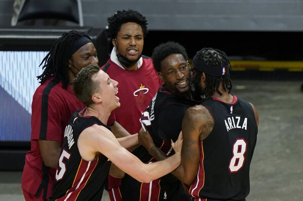 Miami Heat center Bam Adebayo, second from right, is mobbed by teammates after he made the winning shot against the Brooklyn Nets at the end of an NBA basketball game, Sunday, April 18, 2021, in Miami. (AP Photo/Wilfredo Lee)