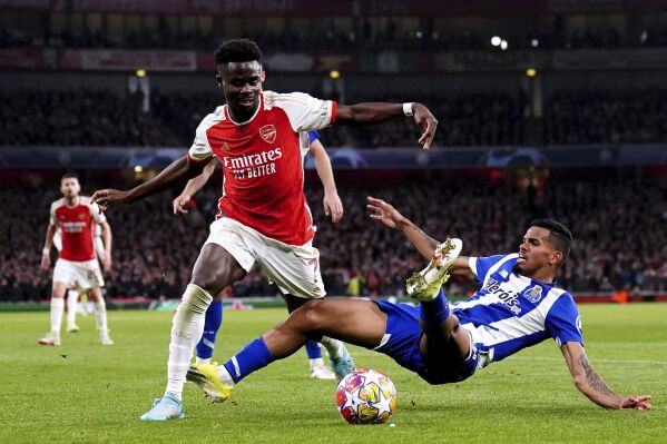 Arsenal's Bukayo Saka, left, and Porto's Galeno battle for the ball during the Champions League round of 16, second leg soccer match between Arsenal and Porto at the Emirates Stadium, London, Tuesday March 12, 2024. (Zac Goodwin/PA via AP)