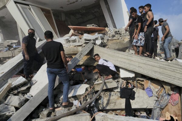 Palestinians look for survivors in the rubble of a destroyed building following an Israeli airstrike in Bureij refugee camp, Gaza Strip, Thursday, Nov. 2, 2023. (AP Photo/Hassan Eslaiah)