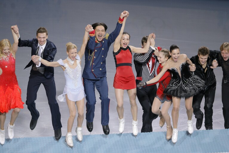 FILE - The Russian team jumps onto the podium during after placing first in the team figure skating competition at the Iceberg Skating Palace during the 2014 Winter Olympics, in Sochi, Russia, Sunday, Feb. 9, 2014. A subsequent doping scandal tainted the success of the Russian team at the Sochi Games. (AP Photo/Vadim Ghirda, File)