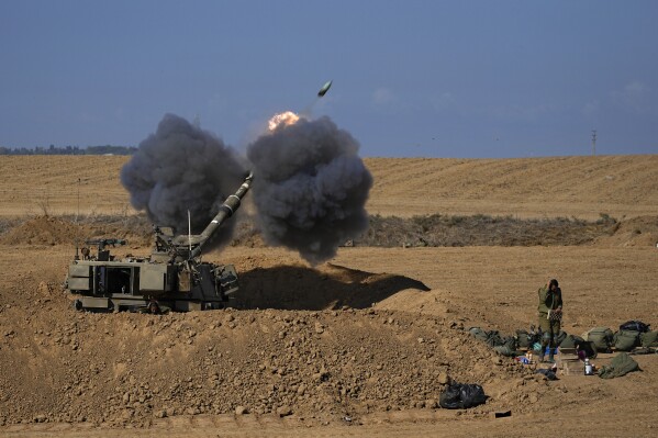 An Israeli mobile artillery unit fired a shell from southern Israel towards the Gaza Strip, in a position near the Israel-Gaza border, Israel, Sunday, Oct. 15, 2023. Israel has been striking targets throughout Gaza since a bloody, cross-border attack by Hamas militants killed over 1,300 Israelis on Oct. 7. (AP Photo/Ohad Zwigenberg)