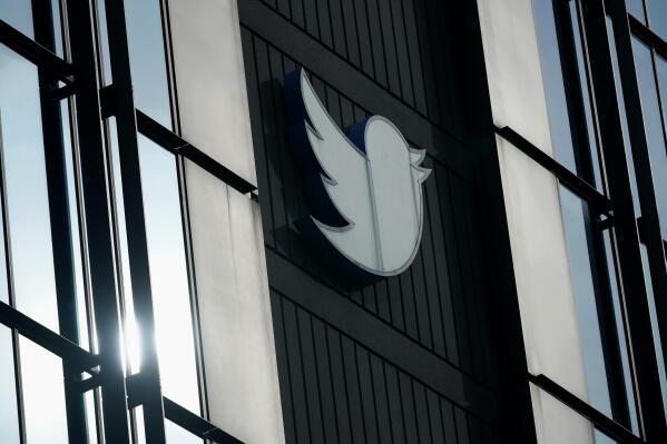 FILE - A Twitter logo hangs outside the company's offices in San Francisco, on Dec. 19, 2022. The Canadian Broadcasting Corporation paused its use of Twitter on Monday, April 17, 2023, after the social media platform owned by Elon Musk stamped CBC’s account with a label the public broadcaster says is intended to undermine its credibility. (AP Photo/Jeff Chiu, File)