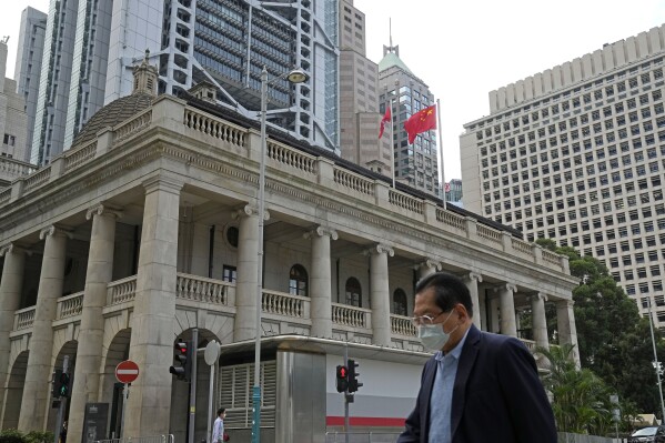 FILE - A pedestrian passes the Court of Final Appeal in Hong Kong, on March 30, 2022. A British judge who resigned from Hong Kong's top court last week said he stepped down because the rule of law in the city is in "grave danger” and judges operate in an “impossible political environment created by China.” (AP Photo/Kin Cheung, File)
