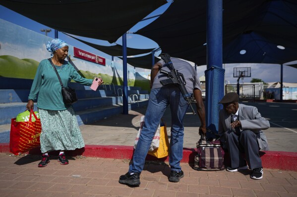 Israelis carry their belongings as they evacuate from the southern Israeli town of Sderot, located near the border with the Gaza Strip, Sunday, Oct. 15, 2023. (AP Photo/Ariel Schalit)