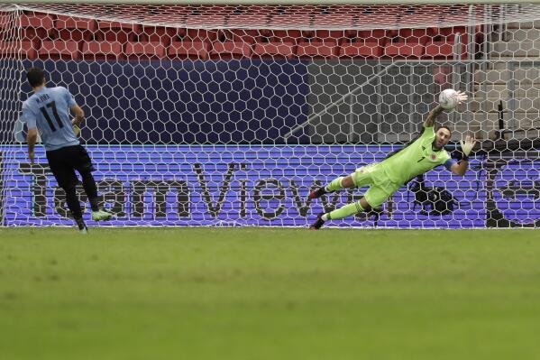 Colombia's goalkeeper David Ospina, right, stops a penalty shot by Uruguay's Matias Vina in a the penalty shootout during a Copa America quarterfinal soccer match at the National stadium in Brasilia, Brazil, Saturday, July 3, 2021. (AP Photo/Bruna Prado)