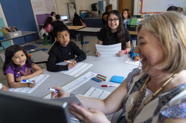 Fifth grade students attend a math lesson with teacher Jana Lamontagne, right, during class at Mount Vernon Community School, in Alexandria, Va., Wednesday, May 1, 2024. (AP Photo/Jacquelyn Martin)