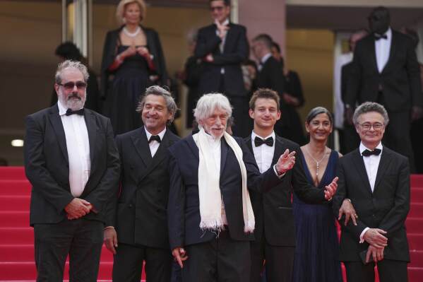 Gustave Kervern, from left, Louis-Do de Lencquesaing, Pierre Richard, Timi-Joy Marbot, Ceyla Lacerda and Olivier Defays pose for photographers upon arrival at the premiere of the film 'Colours of Time' at the 78th international film festival, Cannes, southern France, Thursday, May 22, 2025. (Photo by Lewis Joly/Invision/AP)