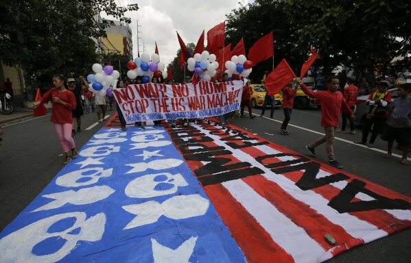 
              Protesters walk on a giant mock U.S. flag during a rally near the venue of ASEAN summit and meetings in Manila, Philippines on Sunday Nov. 12, 2017. The group is protesting against the visit of U.S. President Donald Trump, who is currently on a trip to Asia with the Philippines as his last stop for the ASEAN leaders' summit and related summits between the regional grouping and its Dialogue Partners. (AP Photo/Aaron Favila)
            