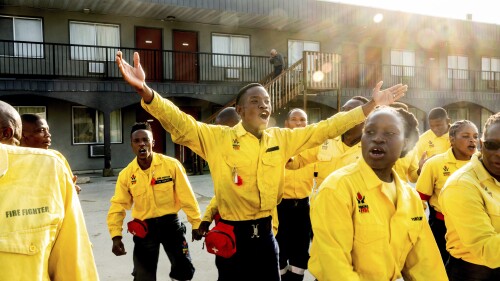 South African firefighters dance during a break during a morning meeting in Fox Creek, Alberta, Tuesday, July 4, 2023.  Several countries, including South Africa, have deployed firefighters to Canada to help local efforts to contain the widespread wildfires.  (AP Photo/Noah Burger)