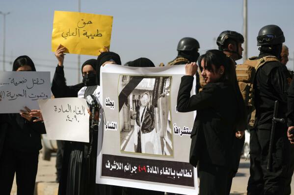 Demonstrators hold placards and a poster with a picture of Tiba Ali, a YouTube star who was recently killed by her father, in Diwaniya, Iraq, Sunday, Feb. 5, 2023. Iraq's Interior Ministry spokesman Saad Maan on Friday announced that Tiba Ali was killed by her father on Jan. 31, who then turned himself into the police. (AP Photo/Hadi Mizban)