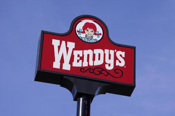 FILE - A sign stands over a Wendy's restaurant on Feb. 25, 2021, in Des Moines, Iowa. Wendy’s said Friday, Jan. 13, 2023, that it is planning a restructuring, including possible corporate layoffs, in an effort to speed decision-making and invest more in new restaurant development. (AP Photo/Charlie Neibergall, File)