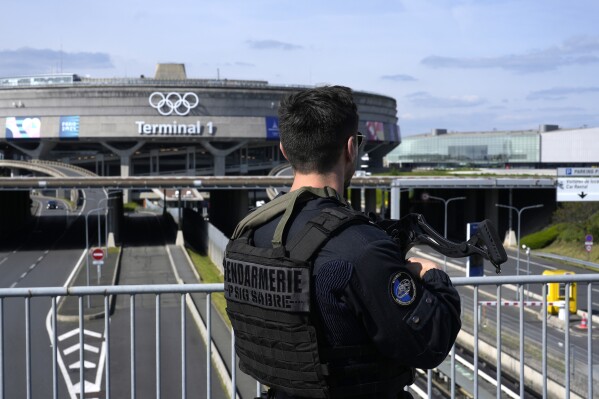 A gendarmes patrol in front of the Charles de Gaulle airport, terminal 1, where the olympic rings were installed, in Roissy-en-France, north of Paris, Tuesday, April 23, 2024 in Paris. (AP Photo/Thibault Camus)