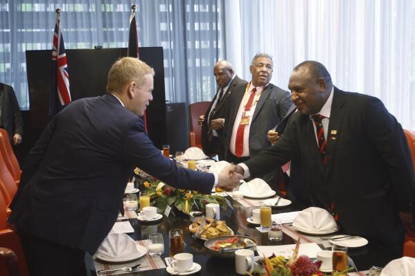 Papua New Guinea Prime Minister James Marape, right, shakes hands with New Zealand Prime Minister Chris Hipkins at a breakfast meeting in Port Moresby, Papua New Guinea, Monday, May 22, 2023. (AP Photo/Nick Perry)