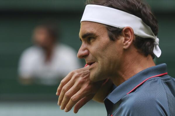 Switzerland's Roger Federer wipes his face during his ATP Tour Singles, Men, Round of 16 tennis match against Canada's Felix Auger-Aliassime in Halle, Germany, Wednesday, June 16, 2021. (Friso Gentsch/dpa via AP)