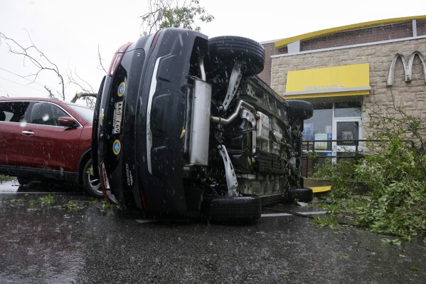 A car is flipped at McDonalds on Old Spanish Trail after an apparent tornado touched down in south Slidell, La., Wednesday, April 10, 2024. (Scott Threlkeld/The Times-Picayune/The New Orleans Advocate via AP)