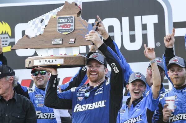 Chris Buescher raises the Cook Out 400 Trophy in Victory Lane after winning a NASCAR Cup Series auto race, Sunday, July 30, 2023, in Richmond, Va. (AP Photo/Skip Rowland)