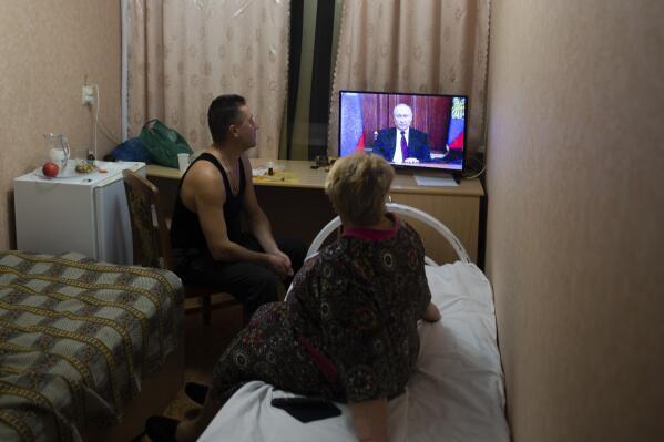 People from the Donetsk and Luhansk regions, the territory controlled by a pro-Russia separatist governments in eastern Ukraine, watch Russian President Vladimir Putin's address at their temporary place in Rostov-on-Don region, Russia, Monday, Feb. 21, 2022. Putin said he would decide later Monday whether to recognize the independence of separatist regions in eastern Ukraine, a move that would ratchet up tensions with the West amid fears that Moscow could launch an invasion of Ukraine imminently. (AP Photo/Denis Kaminev)