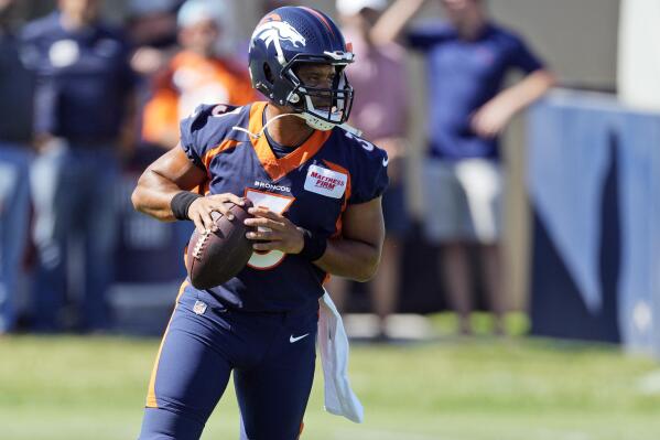 Denver Broncos quarterback Russell Wilson takes part in drills during the opening session of the NFL football team's training camp Wednesday, July 27, 2022, in Centennial, Colo. (AP Photo/David Zalubowski)