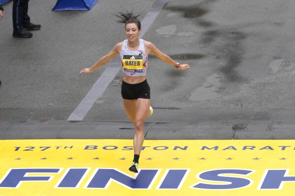 FILE - Emma Bates, of Minnesota, crosses the finish line of the Boston Marathon, April 17, 2023, in Boston. Bates is hoping to improve on last year's fifth-place finish when she lines up for the marathon Monday, April 15, 2024. (AP Photo/Charles Krupa, File)