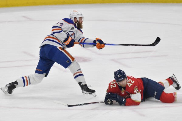 Edmonton Oilers defenseman Mattias Ekholm (14) scores during the first period of Game 2 of the NHL hockey Stanley Cup Finals against the Florida Panthers, Monday, June 10, 2024, in Sunrise, Fla. (AP Photo/Michael Laughlin)