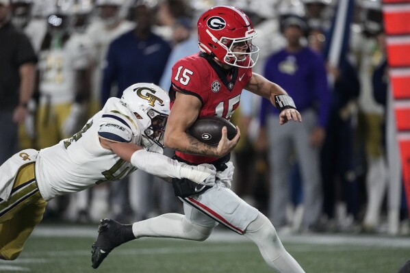 Georgia quarterback Carson Beck (15) is tackled by Georgia Tech linebacker Kyle Efford (44) during the first half of an NCAA college football game, Saturday, Nov. 25, 2023, in Atlanta. (AP Photo/John Bazemore)