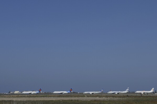 A row of aircrafts belonging to Israeli airlines El Al, Arkia, Israir sit parked in a row along the apron of Cyprus' main airport in Larnaca, Saturday, June 14, 2025. (AP Photo/Petros Karadjias)