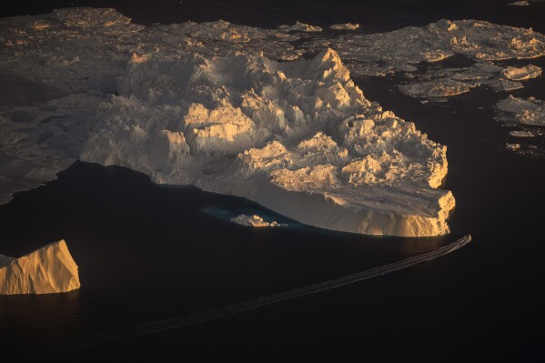 A ship sails alongside a large iceberg in Ilulissat, Greenland, Feb. 18, 2025. (AP Photo/Emilio Morenatti, File)