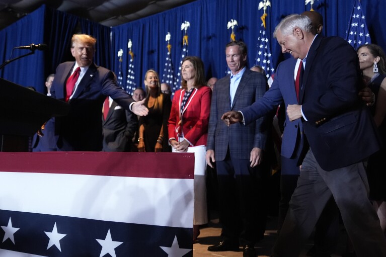 Republican presidential candidate former President Donald Trump invites Sen. Lindsey Graham, R-S.C., to speak at a primary election night party at the South Carolina State Fairgrounds in Columbia, S.C., Saturday, Feb. 24, 2024. (AP Photo/Andrew Harnik)