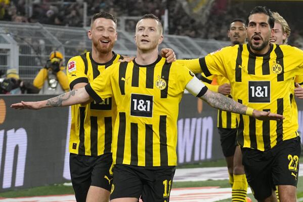 Dortmund's team players celebrate after Marco Reus, centre, scored a penalty, the opening goal, during the German Bundesliga soccer match between Borussia Dortmund and RB Leipzig in Dortmund, Germany, Friday, March 3, 2023. (AP Photo/Martin Meissner)