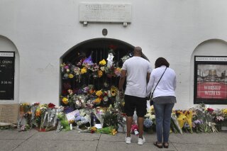 Visitors, including Matt and Marsha Bacoate, leave flowers, notes ad prayers at Emanuel AME Church on the five-year anniversary of the shooting Wednesday, June 17, 2020, in Charleston, S.C.   Dylann Roof, shot a killed nine people while they were in a bible study at the church.   (Grace Beahm Alford/The Post And Courier via AP)