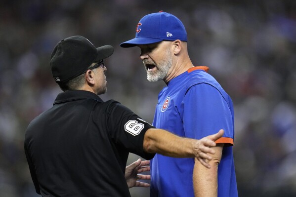 Chicago Cubs manager David Ross, right, argues with umpire Chris Guccione after Cubs' Cody Bellinger was ruled out and not hit by a pitch during the 10th inning of the team's baseball game against the Arizona Diamondbacks on Saturday, Sept. 16, 2023, in Phoenix. The Diamondbacks won 7-6 in 13 innings. (AP Photo/Ross D. Franklin)