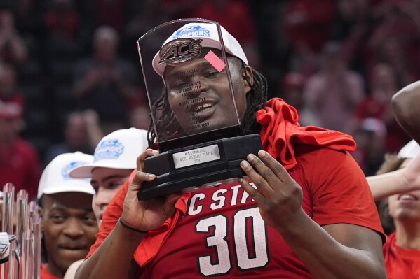 North Carolina State forward DJ Burns Jr. (30) holding his MVP trophy after winning an NCAA college basketball game against North Carolina to win the championship of the Atlantic Coast Conference tournament, Saturday, March 16, 2024, in Washington. North Carolina State won 84-76 (AP Photo/Alex Brandon)