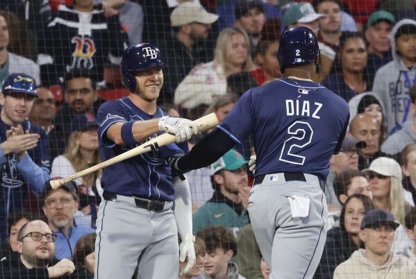 Tampa Bay Rays' Taylor Walls, left, congratulates teammate Yandy Díaz (2) after Díaz scored on a single by Jake Magnum during the fourth inning of a baseball game against the Boston Red Sox at Fenway Park, Monday, June 9, 2025, in Boston. (AP Photo/Mary Schwalm)
