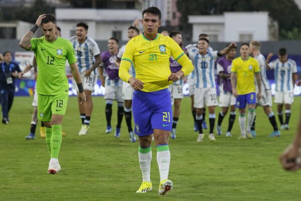 Brazil's Geovane (21) and goalkeeper Matheus Donelli (12) walk off the field after their 0-1 lost against Argentina in the last soccer match of the South America's under-23 pre-Olympic tournament at Brigido Iriarte stadium in Caracas, Venezuela, Sunday, Feb. 11, 2024. (APPhoto/Ariana Cubillos)