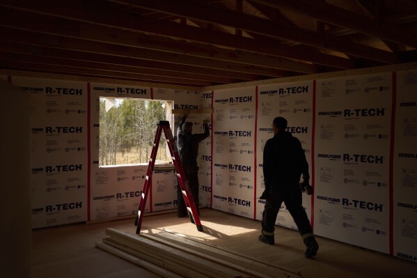 Joe Cleaver II, left, and Derrick Esmailka build an energy efficient home Thursday, May 22, 2025, in Galena, Alaska. (AP Photo/John Locher)