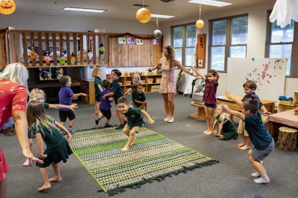 Maui Preparatory Academy students play in the classroom on Tuesday, Oct. 3, 2023, in Lahaina, Hawaii. At one point the academy had taken in about 150 public school students. The three public schools that survived the deadly August wildfire are set to reopen this week. (AP Photo/Mengshin Lin)