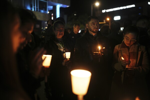 People hold candles during a vigil outside the Santa Fe hospital where Colombian senator and presidential candidate Miguel Uribe Turbay is being treated after he was shot during a campaign rally in Bogota, Colombia, Saturday, June 7, 2025. (AP Photo/Ivan Valencia)