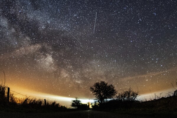 FILE - The Lyrid meteor shower is seen over Burg on the Baltic Sea island of Fehmarn off Germany, Friday, April 20, 2018. The Lyrids occur every year in mid-to-late April. Peak activity for 2024 happens Sunday, April 21 into Monday, April 22, with 10 to 20 meteors expected per hour, weather permitting. Viewing lasts through April 29. (Daniel Reinhardt/dpa via AP, File)