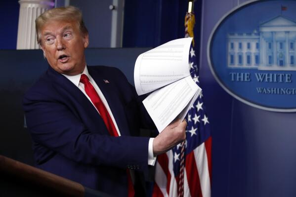 FILE President Donald Trump holds up papers as he speaks about the coronavirus in the James Brady Press Briefing Room of the White House on April 20, 2020, in Washington.  President Joe Biden is ordering the release of Trump White House visitor logs to the House committee investigating the riot of Jan. 6, 2021, once more rejecting former President Donald Trump’s claims of executive privilege. The committee has sought a trove of data from the National Archives, including presidential records that Trump had fought to keep private.  (AP Photo/Alex Brandon, File)