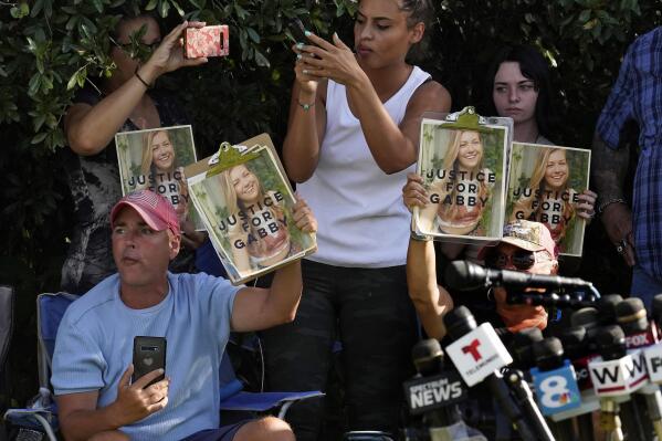 FILE - In this Wednesday, Oct. 20, 2021, file photo, Supporters of Gabby Petito hold up photos of Gabby after a news conference Wednesday, Oct. 20, 2021, in North Port, Fla. The FBI on Thursday, Oct. 21, 2021 identified human remains found in a Florida nature preserve as those of Brian Laundrie, a person of interest in the death of girlfriend Gabby Petito while the couple was on a cross-country road trip. (AP Photo/Chris O'Meara, File)