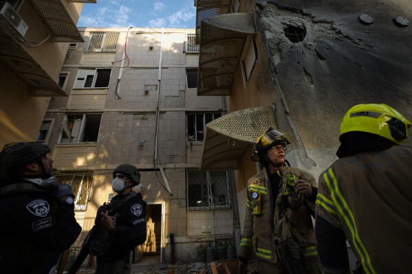 Israeli security forces inspect a damaged residential building after it was hit by a rocket fired from the Gaza Strip, in Sderot, Israel, Tuesday, Oct. 17, 2023. (AP Photo/Ariel Schalit)