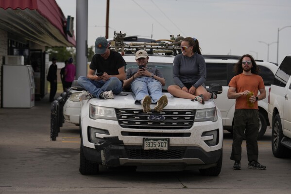 Integrated Remote & In-Situ Sensing (IRISS) lab out of the University of Colorado Boulder and Project ICECHIP members, from left, Céu Gomez-Faulk, Ryan Downey, Madison Ritsch and Andrew Mord sit atop what they call "Tracker One" in the Allsup's Convenience Store parking lot waiting for a storm, Wednesday, June 4, 2025, in Tucumcari, N.M. (AP Photo/Carolyn Kaster)